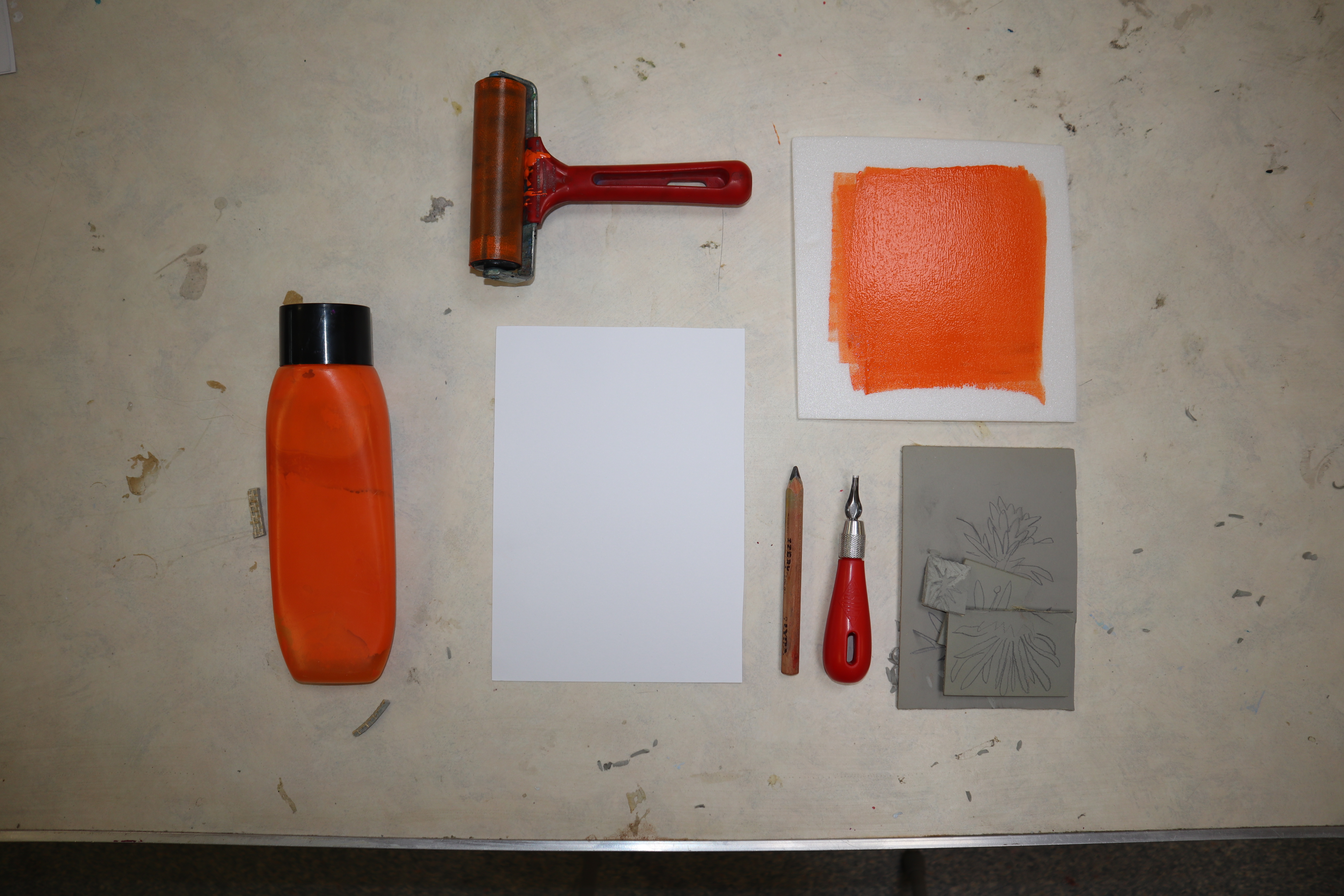 a flat lay photo of equipment and materials used for printing with lino
