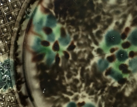 A dark painting with black and green blotches, looks like it's  a close of up something